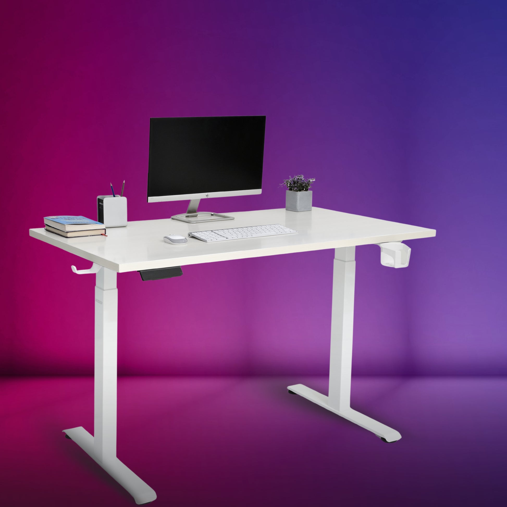 An adjustable standing desk with a white tabletop, black telescopic frame, and dual motor mechanism, equipped with a computer monitor, stationery, and a potted plant on top.